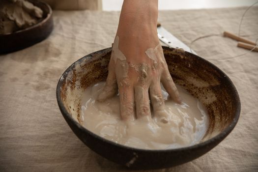 Crop ceramist with hand in clay