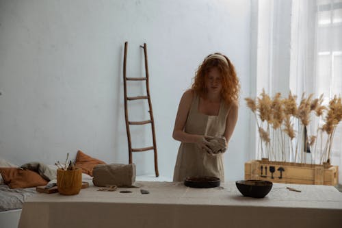 Redhead woman working with clay