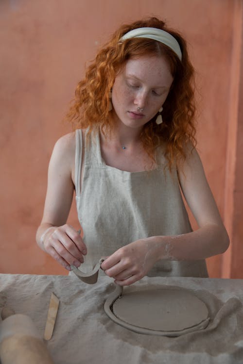 Redhead woman working with clay