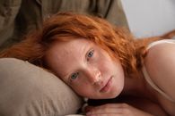 Ginger woman lying on lap of boyfriend