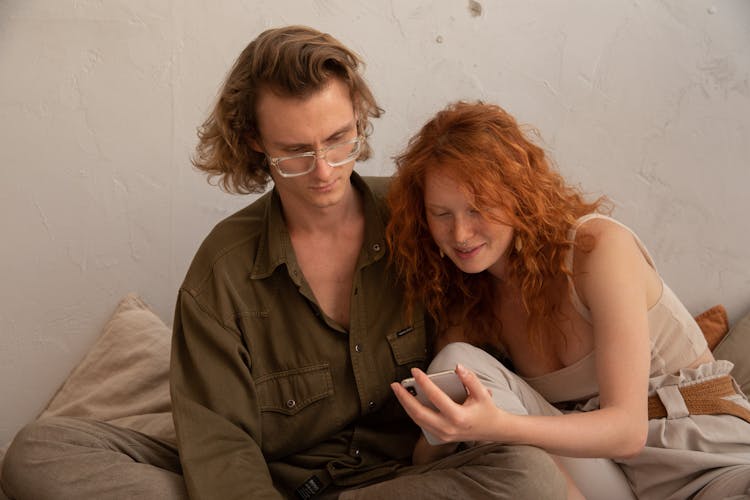 Cheerful Couple Using Smartphone At Home