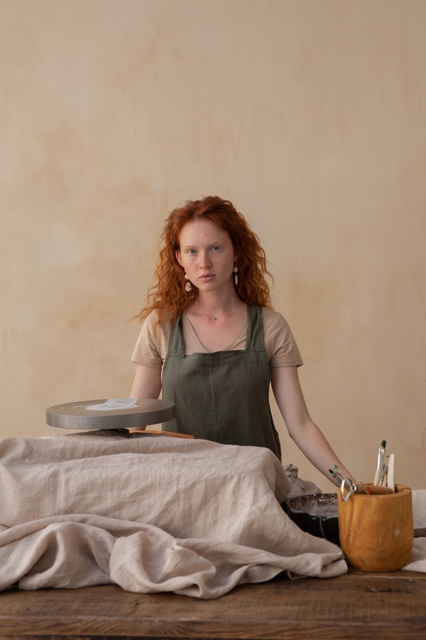 Portrait of a potter in an apron at her wheel