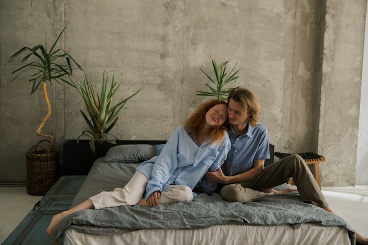 Happy Couple Resting On Bed