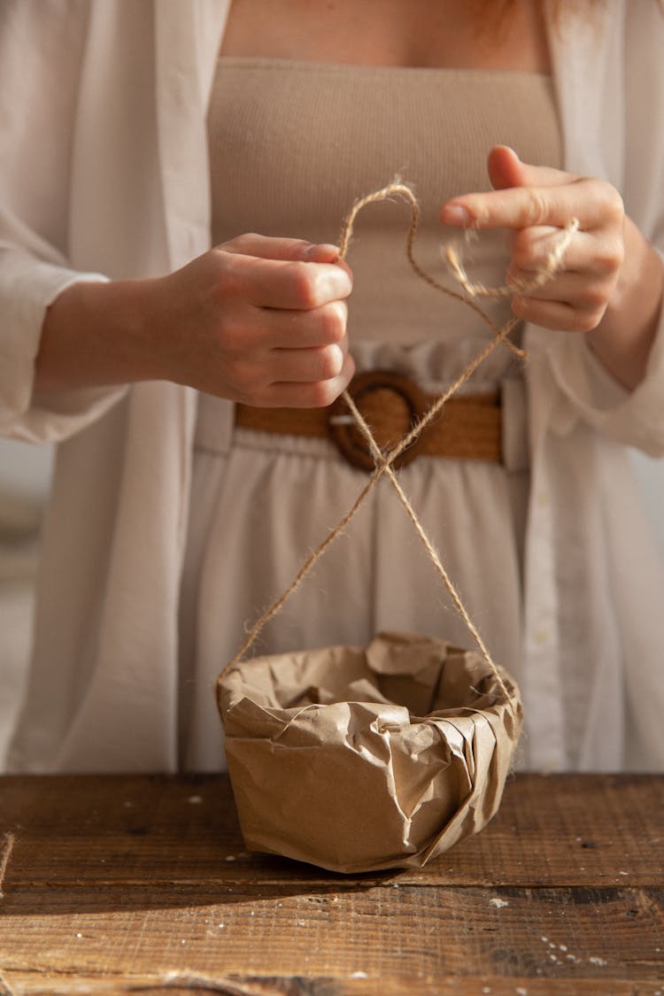 Crop Woman Tying Rope On Bowl