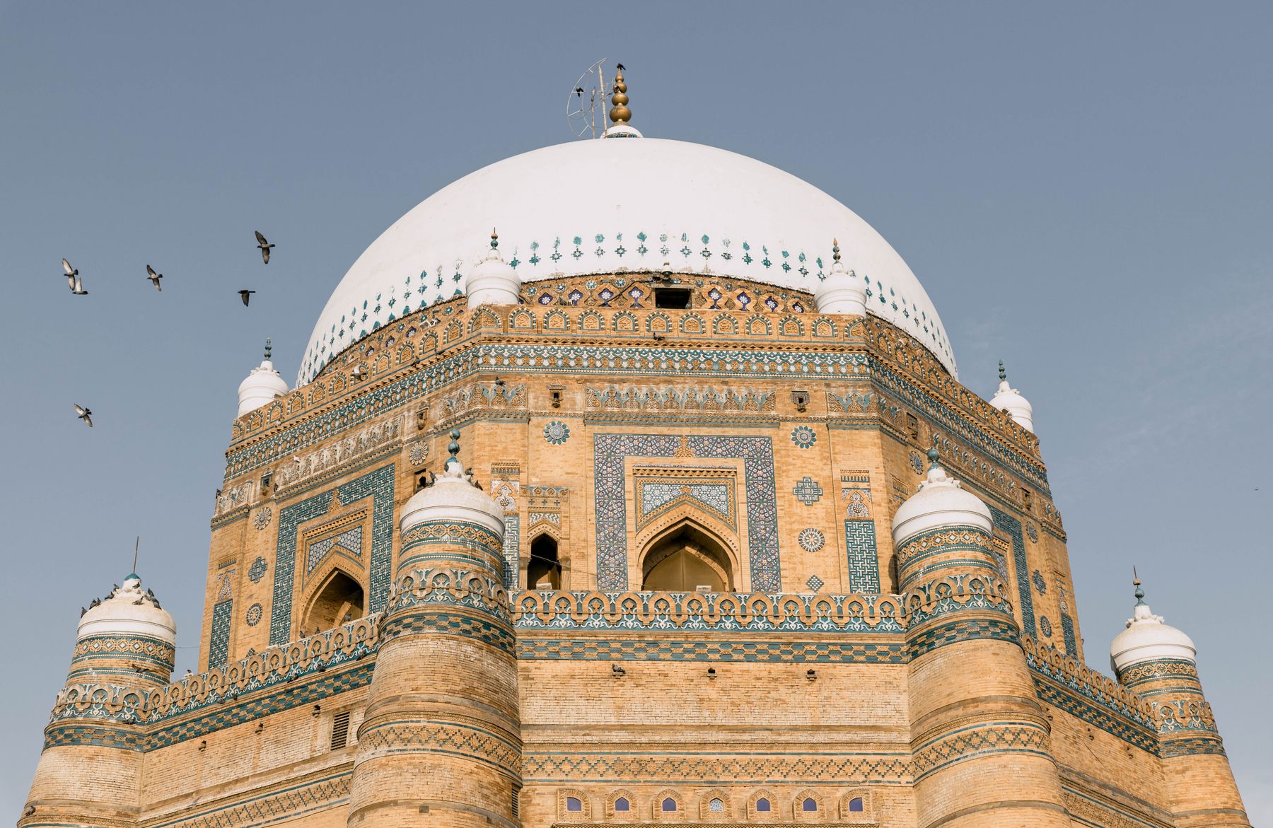 The stunning architectural details of the Tomb of Shah Rukn-e-Alam in Multan, Pakistan under a blue sky.