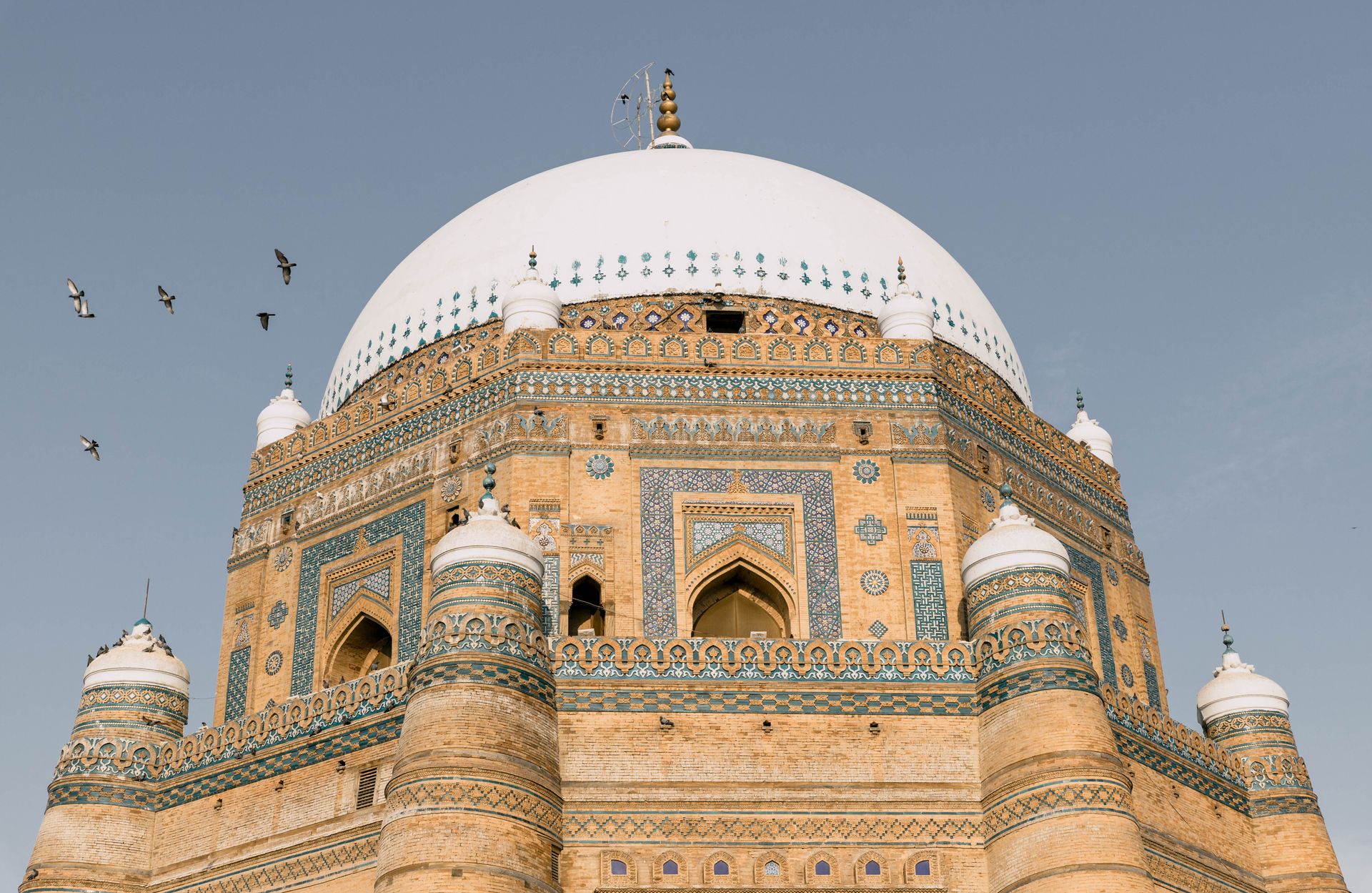 The stunning architectural details of the Tomb of Shah Rukn-e-Alam in Multan, Pakistan under a blue sky.