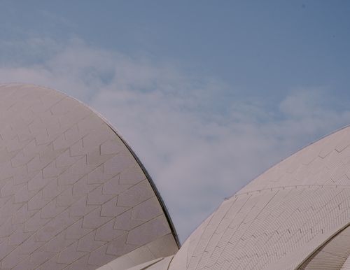 Free Artistic close-up of the Sydney Opera House's iconic sails under a clear blue sky. Stock Photo