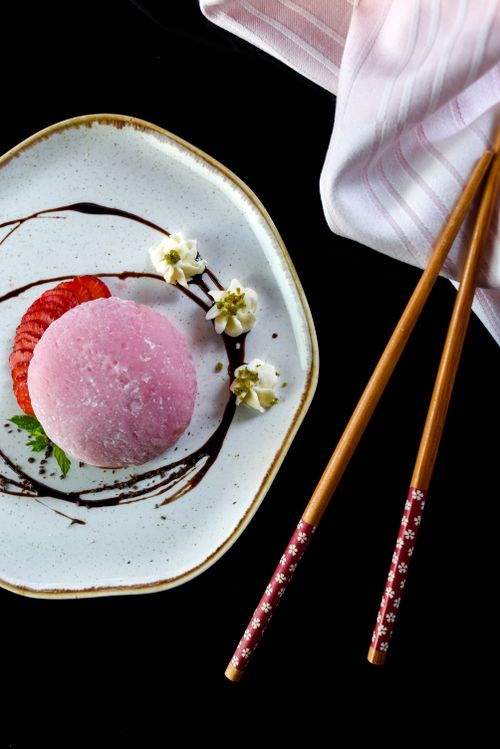 Free Elegant pink dessert with floral garnish and chopsticks on a white plate, perfect for gourmet dining. Stock Photo