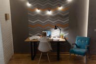 一个小男孩在课桌上参加在线课程，桌上放着书和电脑