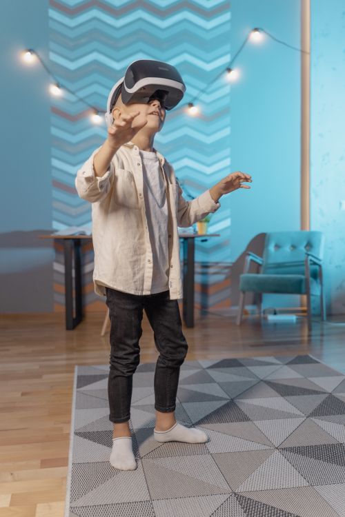 Free A young boy experiencing virtual reality indoors using VR goggles. Stock Photo