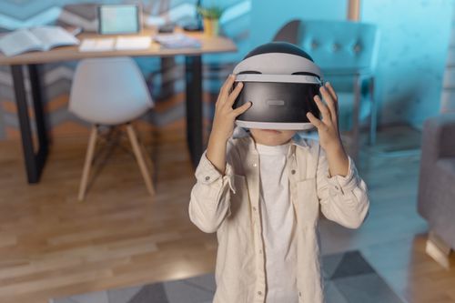 Free Young child immersed in virtual reality with VR headset indoors. Stock Photo