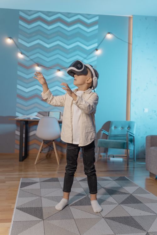 Free A young boy enjoying a virtual reality experience at home, wearing VR goggles. Stock Photo