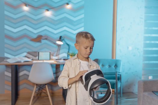 Young boy holding a VR headset in a modern living room setting.