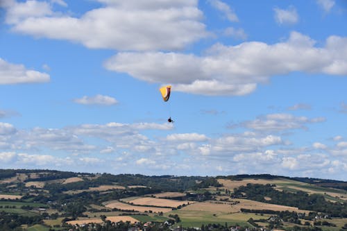 Person Parachuting Over Farmlands