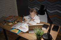 Boy in White Long Sleeve Shirt Writing on White Paper