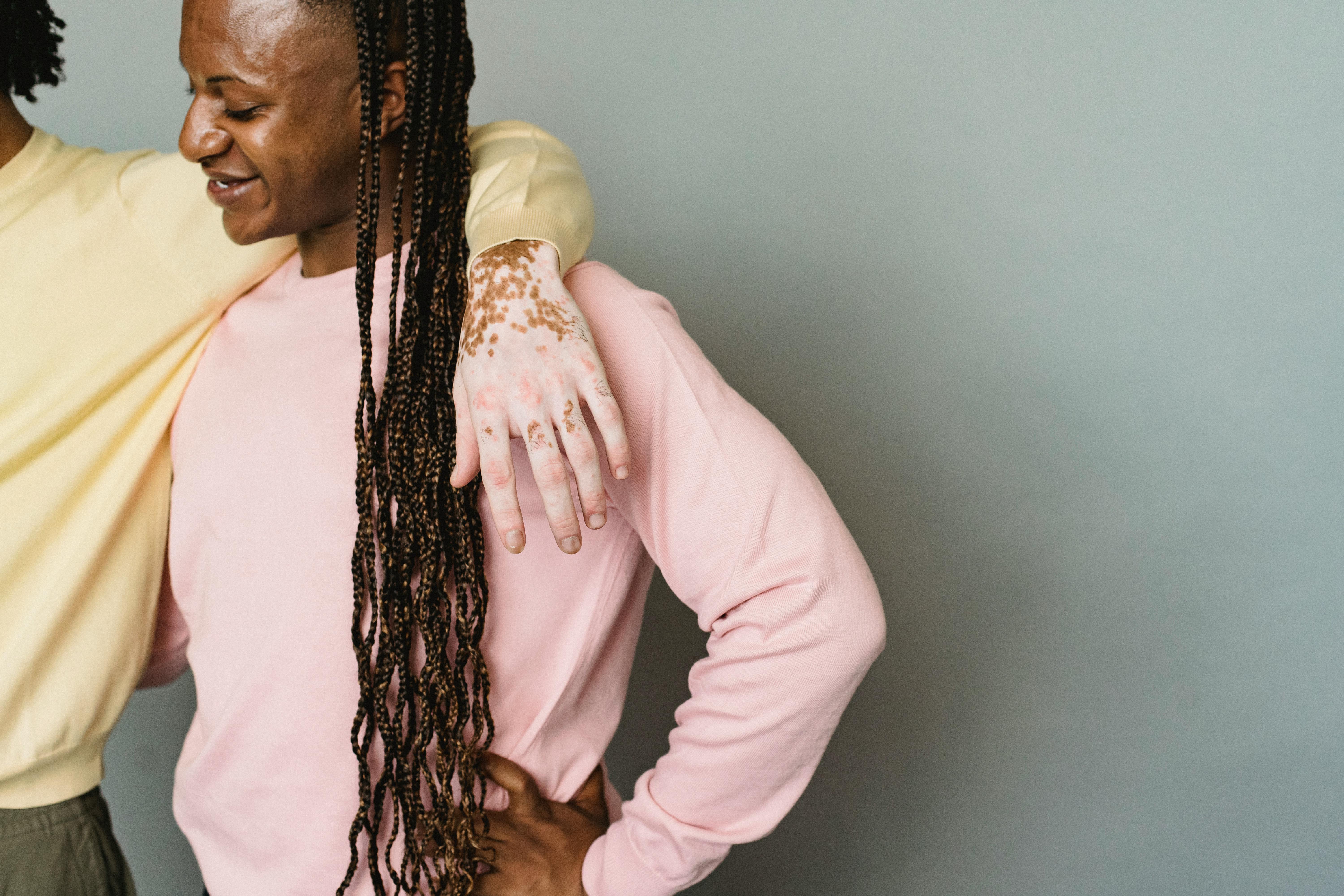 crop homosexual couple embracing in studio