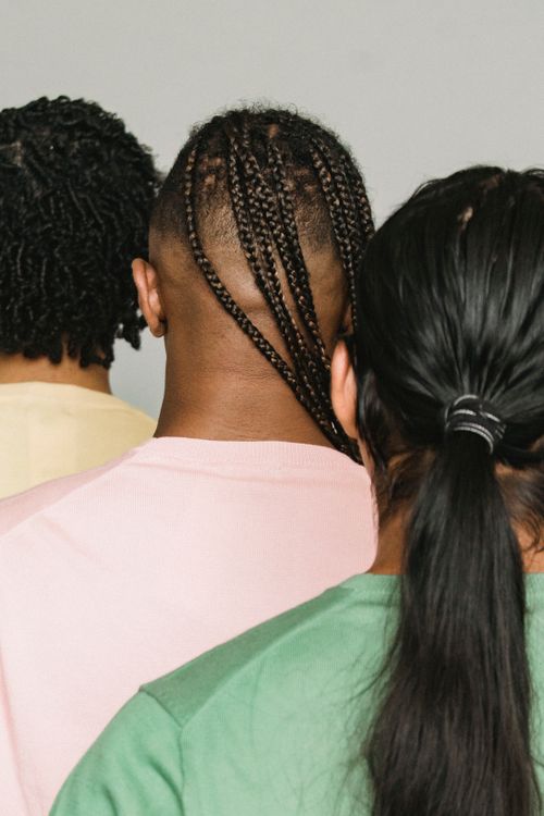 Free Back view of faceless male models in stylish clothes with various hairstyles standing close in studio Stock Photo