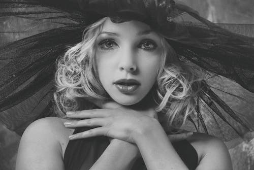 Woman Wearing a Headpiece with Hands on Neck