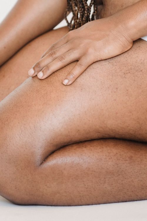 Free Unrecognizable plus size African American person with Afro braids wearing underwear sitting on knees with hand on thigh in studio Stock Photo