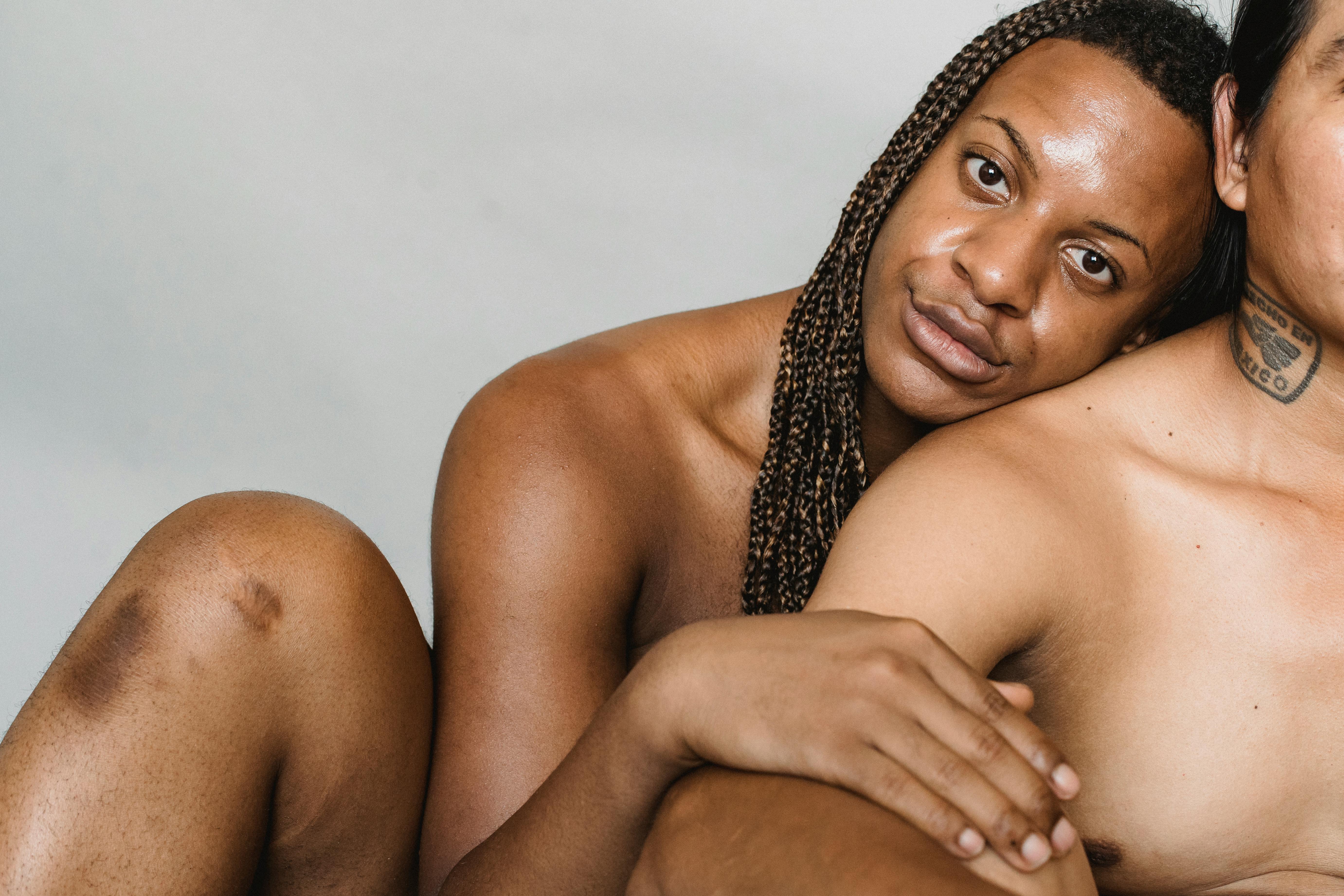 crop shirtless multiethnic men hugging in studio