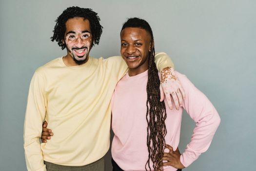 Happy black men hugging in studio
