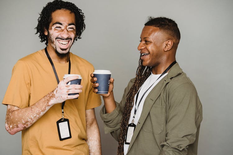 Happy African American Colleagues Standing With Cups Of Coffee And Laughing