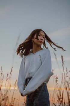 日落时分，一位年轻女子在乡村田野中享受宁静的时刻