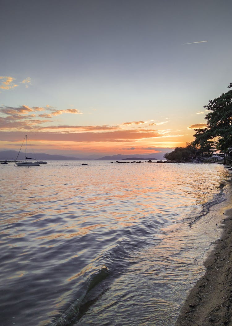 White Sailboat On Sea During Sunset