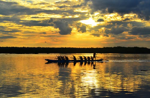Free People Paddling a Boat During Sunset Stock Photo