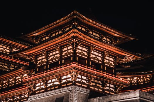 A stunningly illuminated traditional Asian temple showcasing intricate architectural details against a night sky.