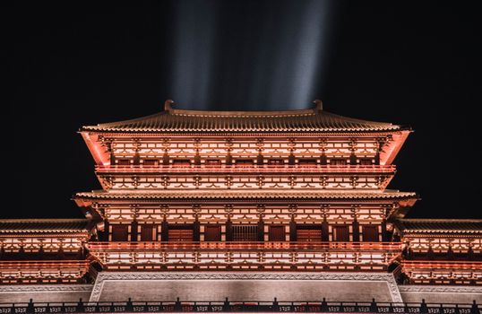 夜晚，一座美丽的中国传统建筑在灯光映照下，展现出精致的细节与活力