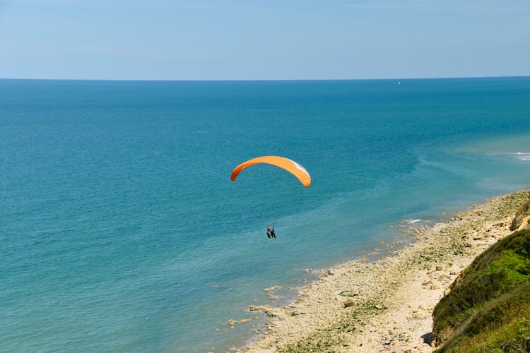 Person Parachuting Above The Sea