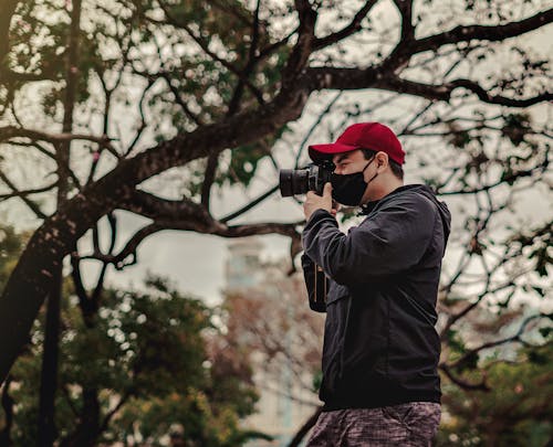 Man Wearing a Black Jacket Taking Pictures