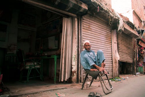 Man Wearing Blue Outfit Sitting on a Chair