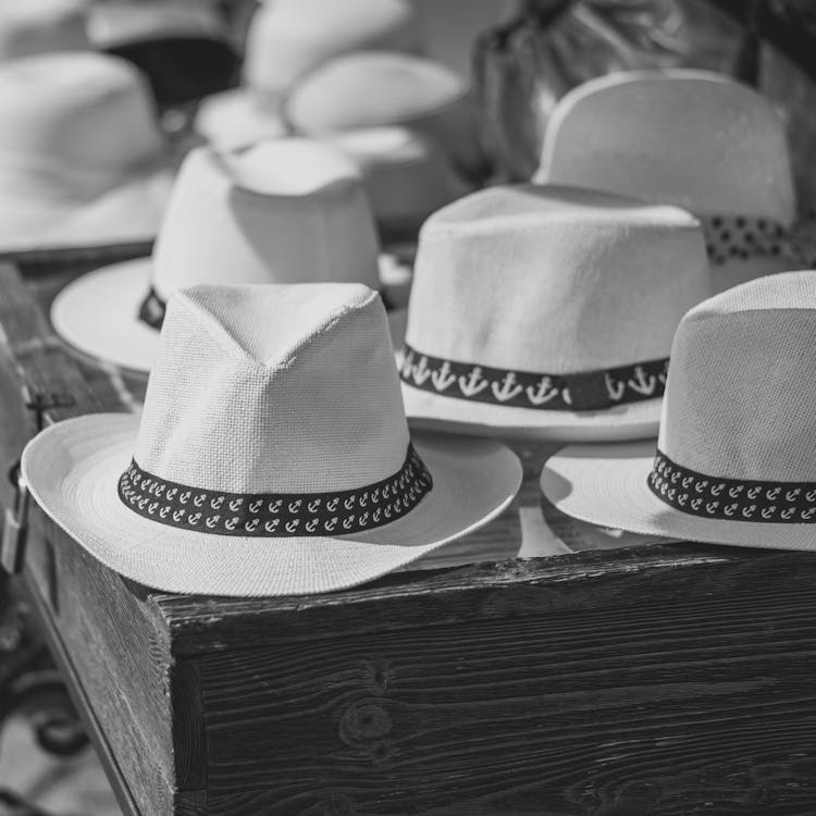 Grayscale Photo Of Cowboy Hats On A Table