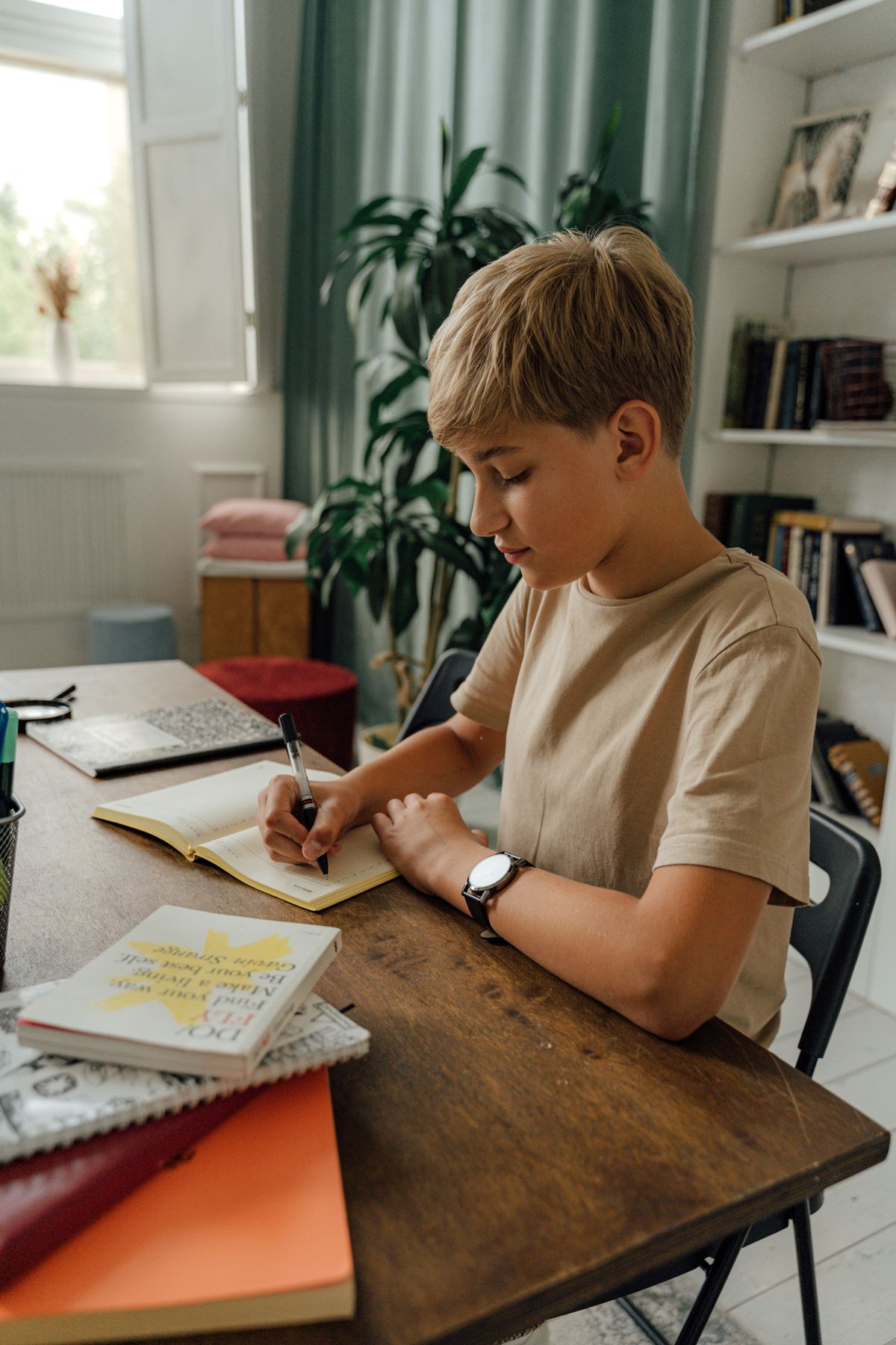 A student writing intently at a desk