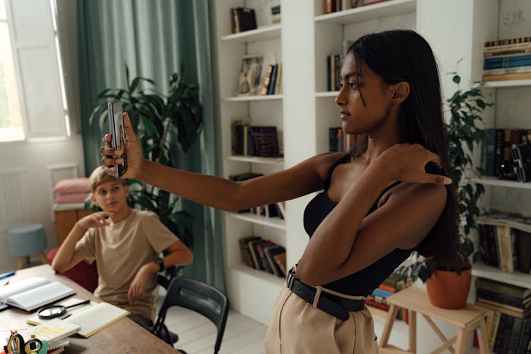 Woman Doing Selfie While The Boy Is Looking At Her 