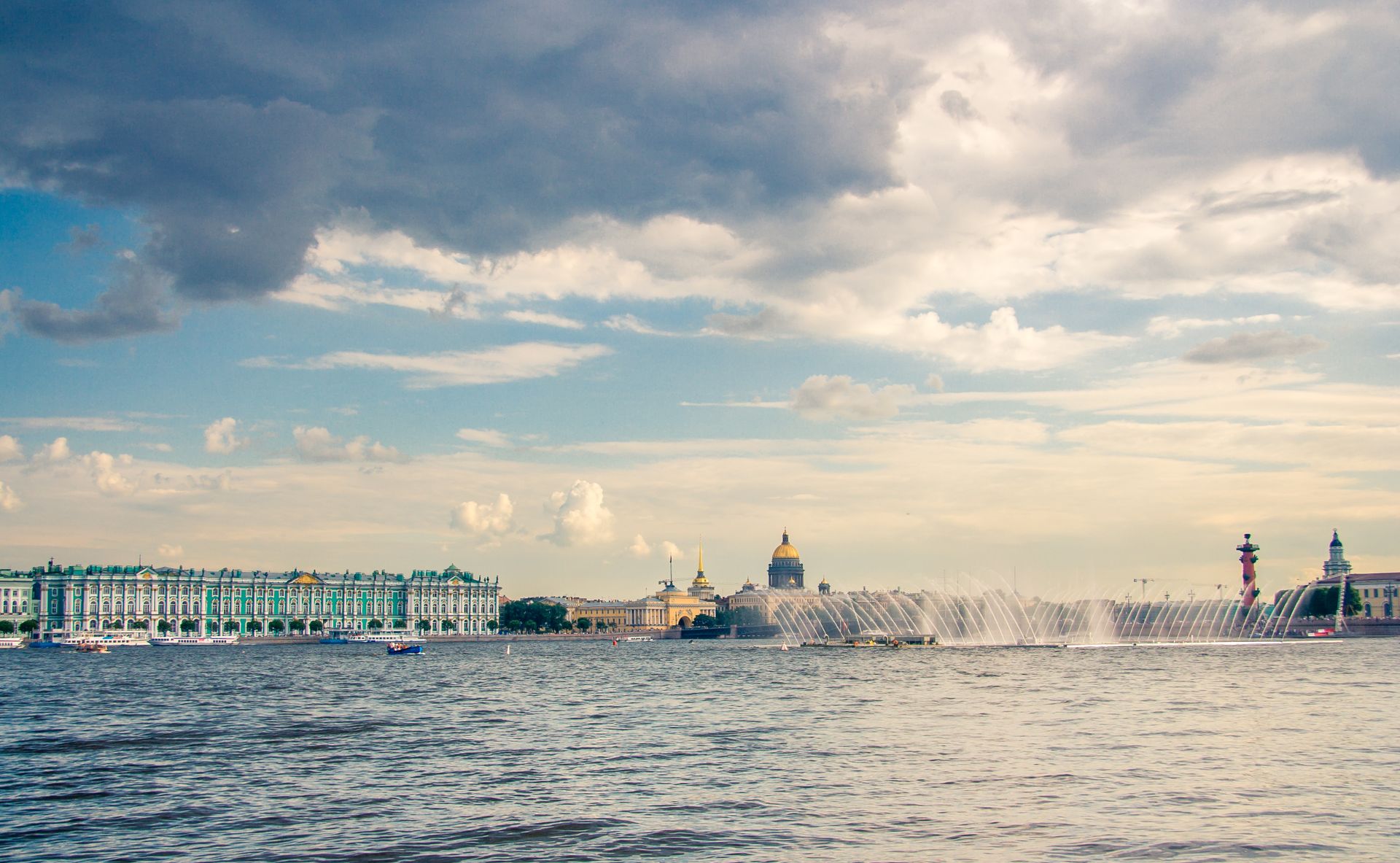 Panoramic view of Sankt Petersburg's historic landmarks along the waterfront on a cloudy day.