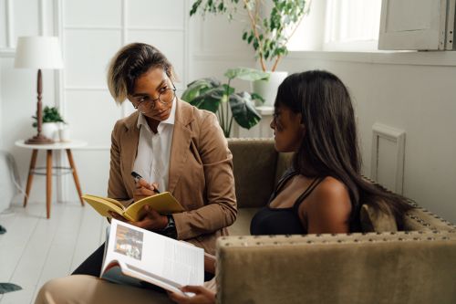 Free A teacher and student engaged in a conversation in a cozy setting. Stock Photo