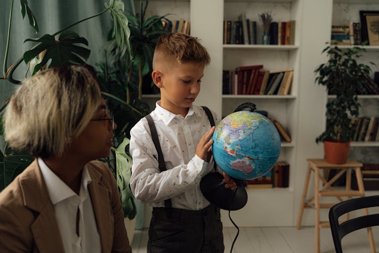 A Boy Holding A Globe