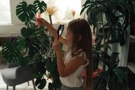 一个年轻女孩在室内用放大镜和试管检查植物