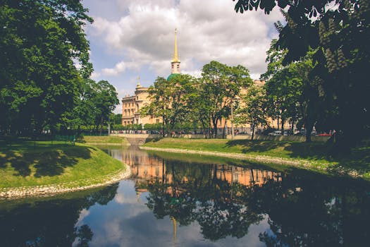 米哈伊洛夫斯基城堡的倒影映在圣彼得堡一条宁静的运河上，周围环绕着郁郁葱葱的绿色植物