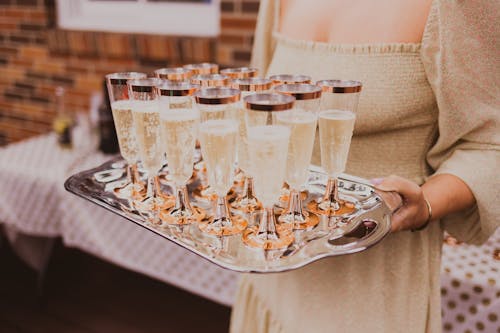 Free Crop woman with tray of champagne glasses Stock Photo