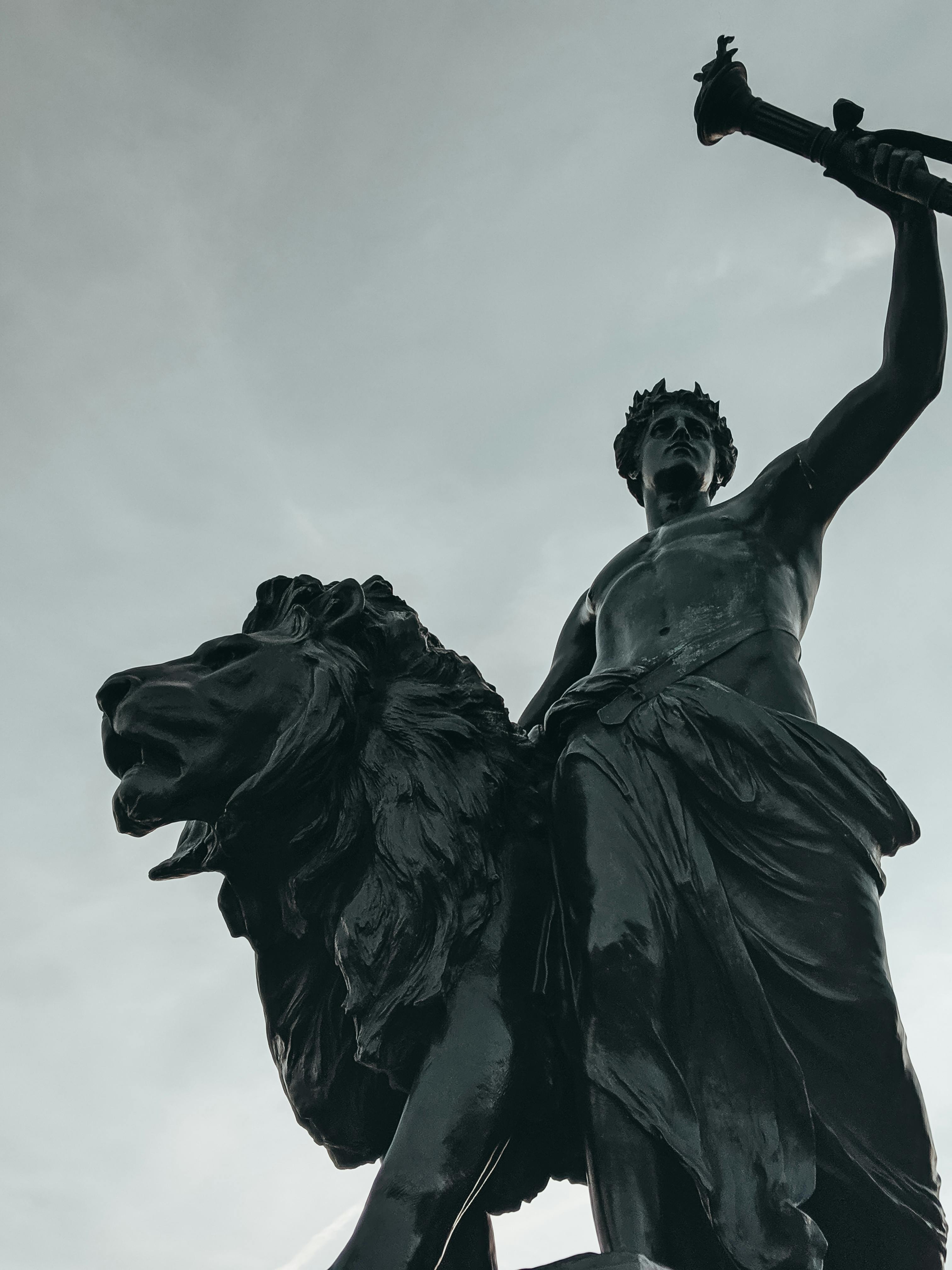 black statue of a man riding a lion