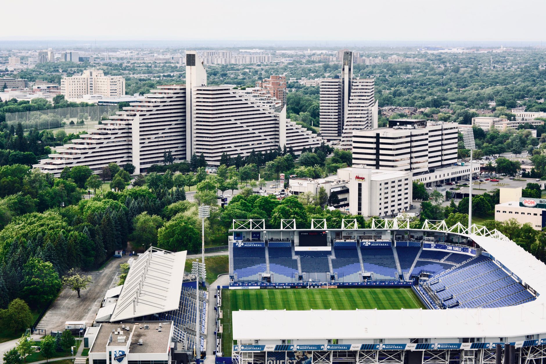 Aerial view of Toronto football stadium surrounded by city skyline, banners ready for World Cup