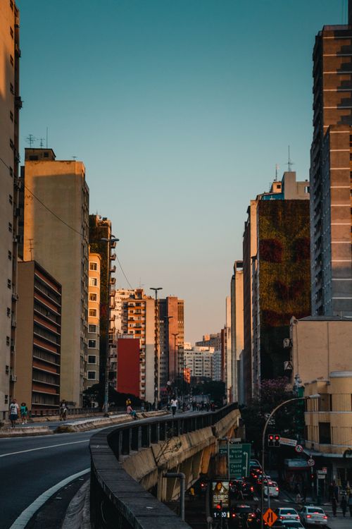 Free Perspective view of contemporary busy city street with tall residential buildings and elevated highway in daylight Stock Photo