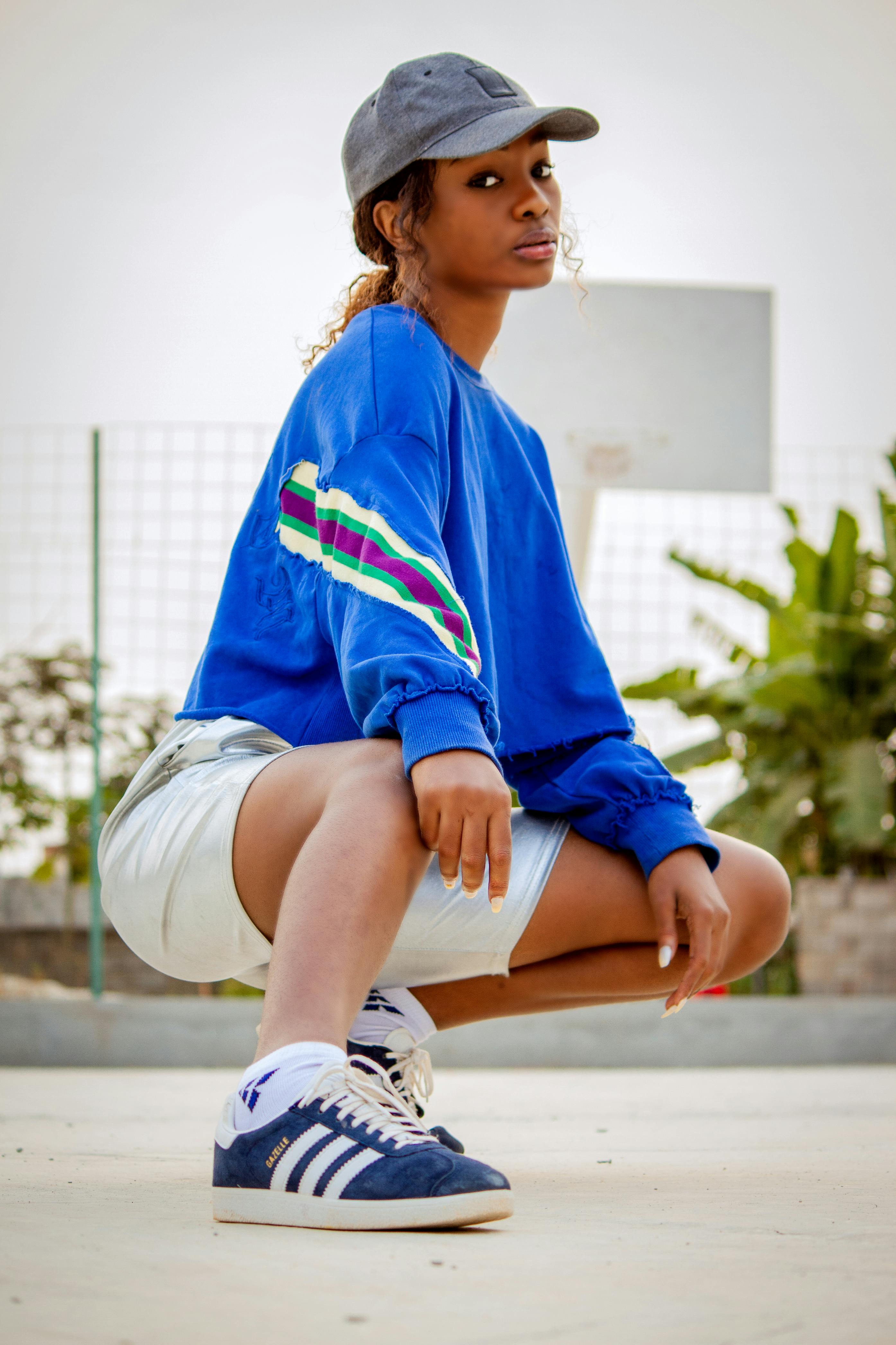 Stylish black woman squatting on sports ground · Free Stock Photo