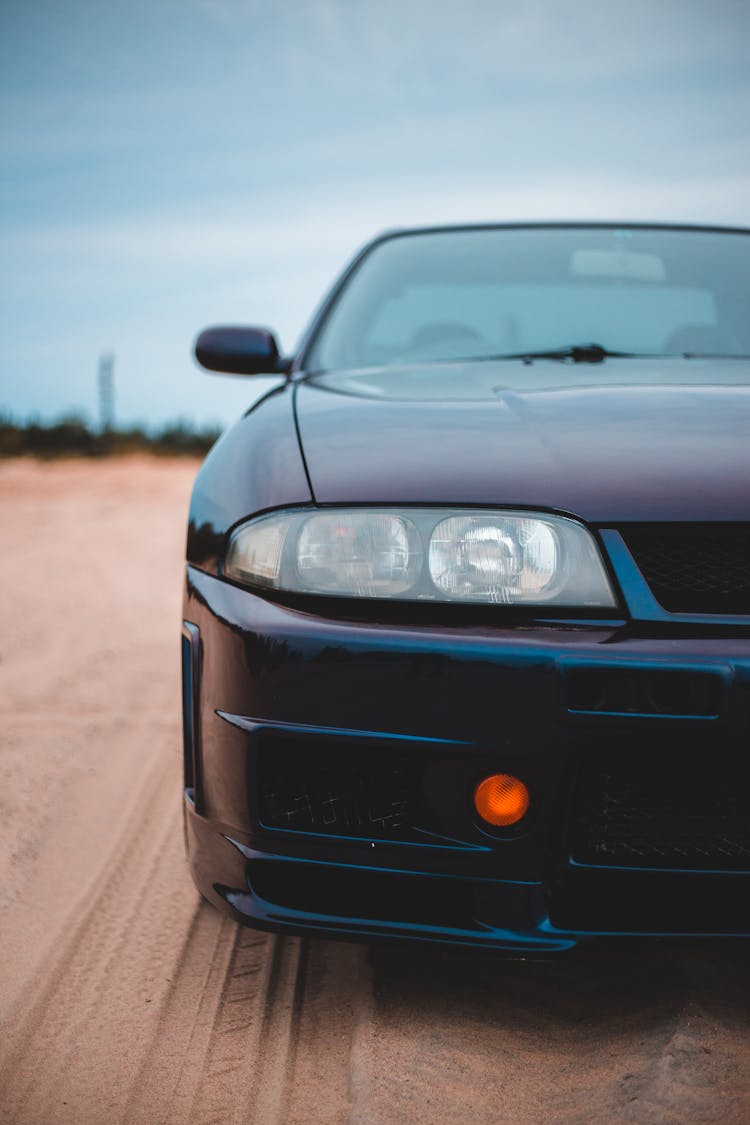 Front Bumper Of Sports Car On Sandy Land