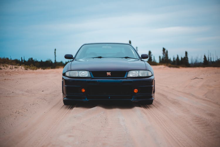 Luxury Car On Sandy Land With Traces