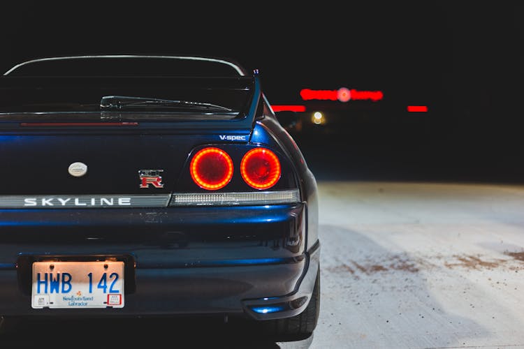 Sports Car With Red Taillights On Pavement At Night